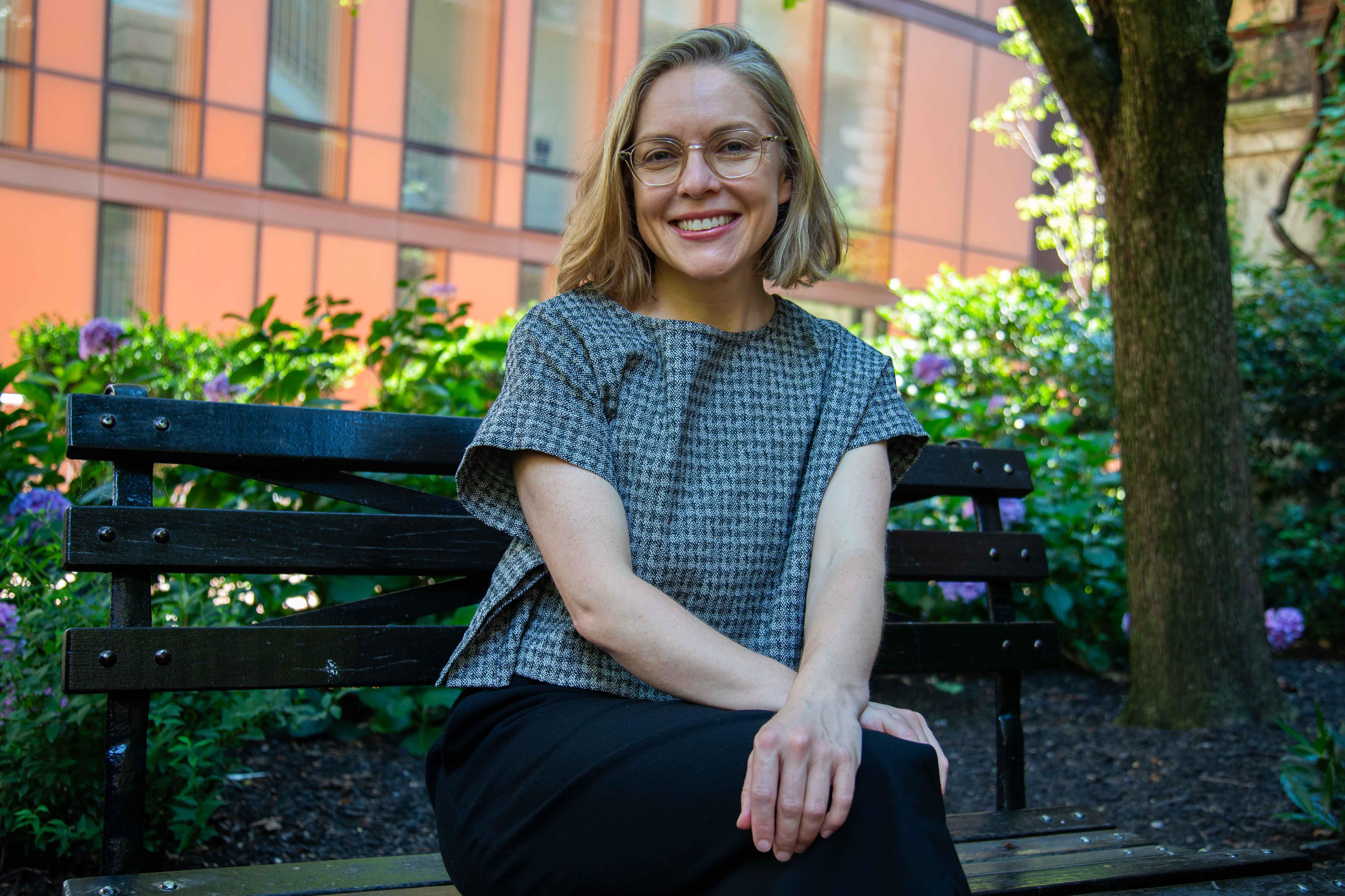 Serena Longley headshot. she is sitting on a bench